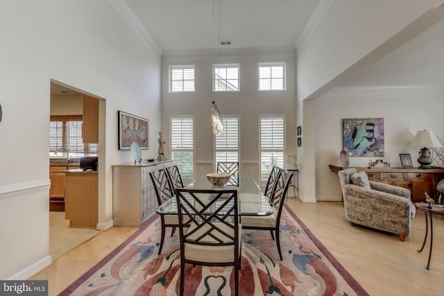 13605 Autumn End Ter, Laurel, MD 20707 - dining space with crown molding, light wood-style floors, baseboards, and a towering ceiling