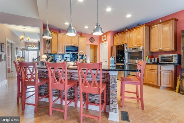 15149 Coultlands Reach, Milton, DE 19968 - kitchen with a kitchen bar, stainless steel double oven, a chandelier, fridge, and recessed lighting