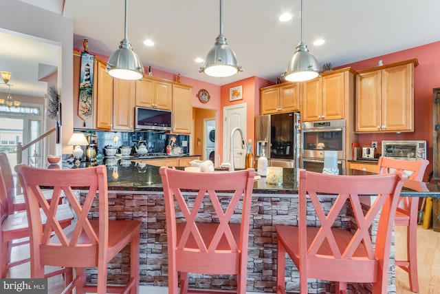 15149 Coultlands Reach, Milton, DE 19968 - kitchen featuring appliances with stainless steel finishes, decorative backsplash, decorative light fixtures, light brown cabinets, and recessed lighting