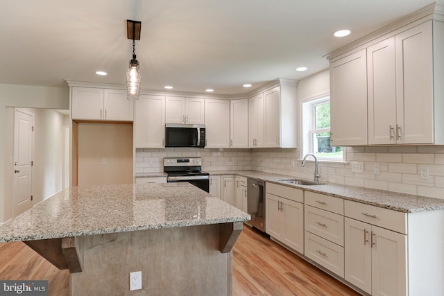 1406 Amosite Rd, Bainbridge, PA 17502 - kitchen with stainless steel appliances, a sink, a breakfast bar, light wood-type flooring, and a center island