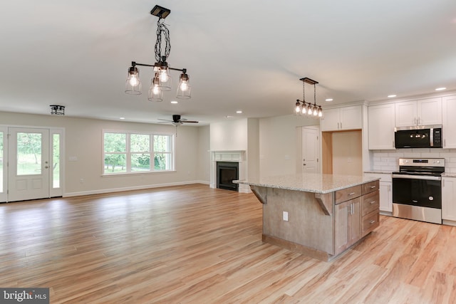 1406 Amosite Rd, Bainbridge, PA 17502 - kitchen featuring appliances with stainless steel finishes, open floor plan, a fireplace, light wood finished floors, and recessed lighting