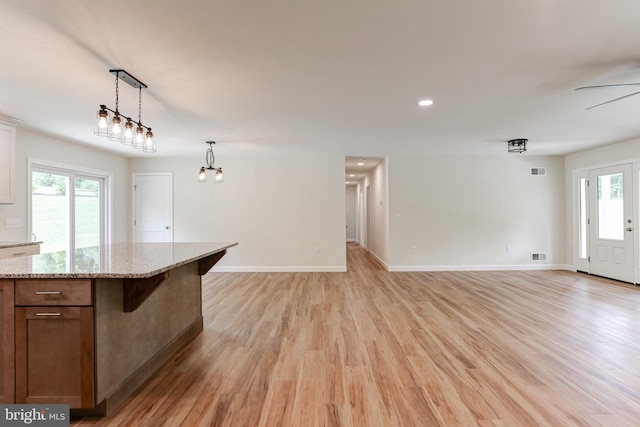 1406 Amosite Rd, Bainbridge, PA 17502 - kitchen with light wood finished floors, pendant lighting, light stone counters, baseboards, and open floor plan