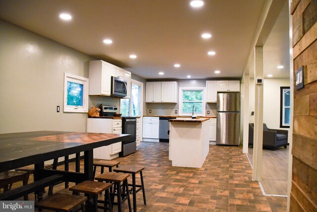 38 Behm Ln, Colora, MD 21917 - kitchen with appliances with stainless steel finishes, a kitchen island, recessed lighting, white cabinets, and brick patterned flooring