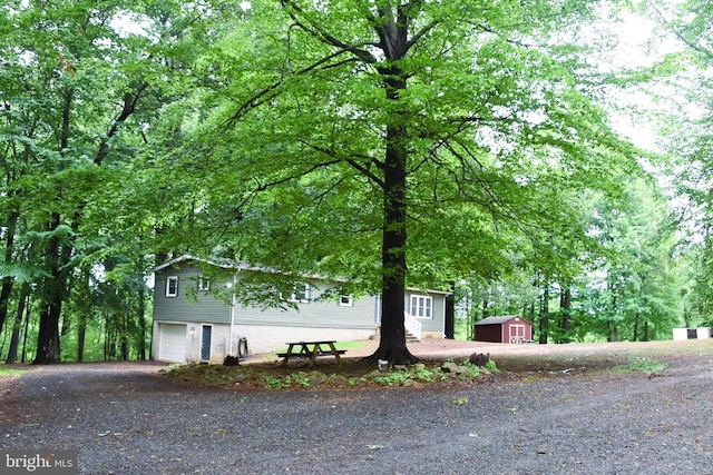 38 Behm Ln, Colora, MD 21917 - view of property hidden behind natural elements featuring an attached garage, driveway, a shed, and an outbuilding