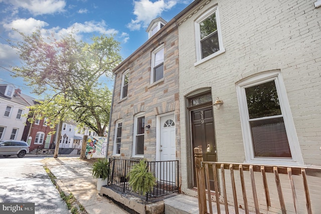 townhome / multi-family property with stone siding and a residential view