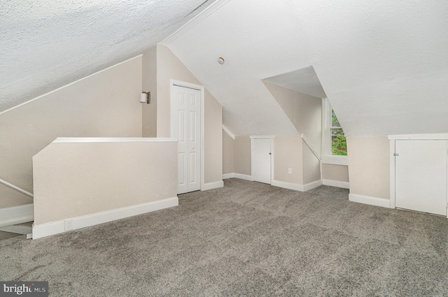bonus room with a textured ceiling, carpet flooring, vaulted ceiling, and baseboards