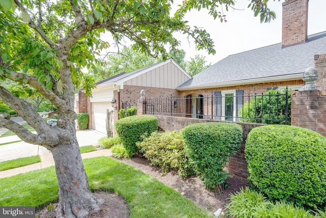 10518 Meadow Bridge Ln, Fairfax, VA 22030 - view of front of home featuring brick siding, a garage, a shingled roof, board and batten siding, and a chimney