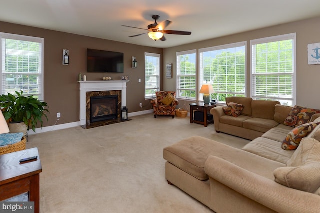 carpeted living room featuring a ceiling fan, healthy amount of natural light, and baseboards