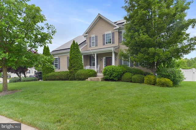 view of front of home featuring solar panels and a porch