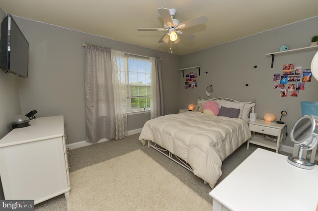 bedroom with light colored carpet, baseboards, and a ceiling fan