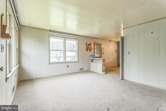 unfurnished living room featuring carpet and baseboards