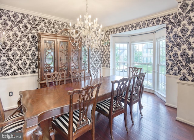 dining space with wallpapered walls, a chandelier, wainscoting, ornamental molding, and wood finished floors