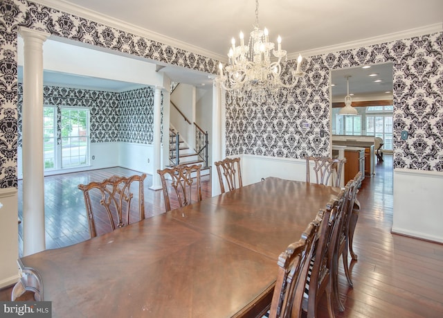 unfurnished dining area with wallpapered walls, wood-type flooring, healthy amount of natural light, crown molding, and a chandelier