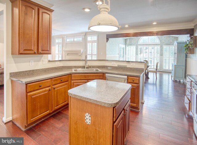 kitchen featuring a sink, dishwasher, a peninsula, plenty of natural light, and ornamental molding