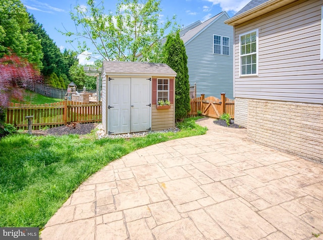view of patio / terrace featuring a shed, an outdoor structure, and a fenced backyard