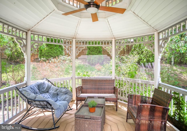 sunroom with ceiling fan, healthy amount of natural light, and vaulted ceiling