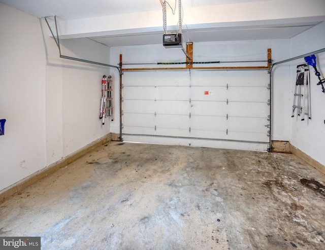 garage with a garage door opener and baseboards