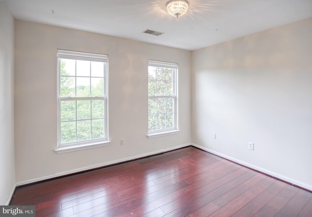 spare room featuring wood finished floors and baseboards