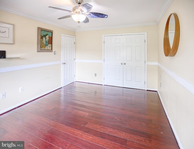unfurnished bedroom with hardwood / wood-style flooring, ornamental molding, baseboards, ceiling fan, and a closet