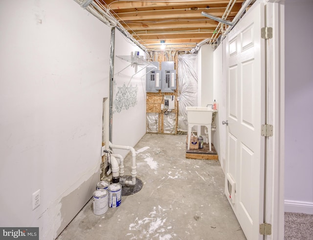 unfinished below grade area with electric panel and a sink