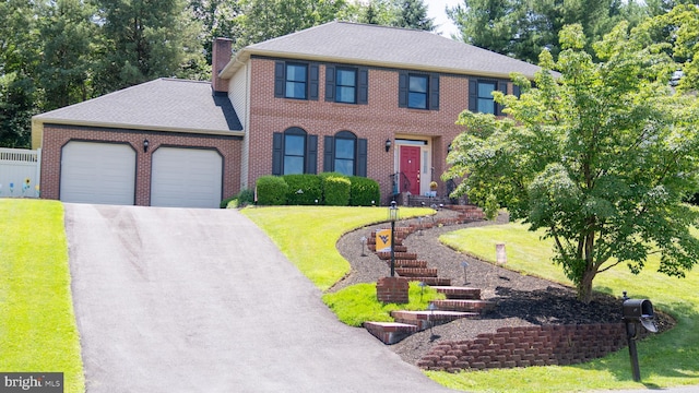 1042 Country Club Rd, Camp Hill, PA 17011 - colonial-style house featuring an attached garage, driveway, a front lawn, a chimney, and brick siding