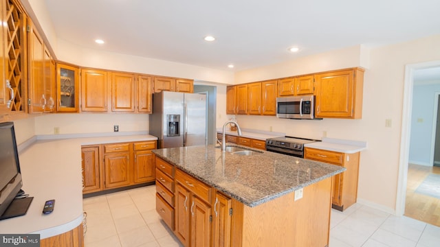 1042 Country Club Rd, Camp Hill, PA 17011 - kitchen featuring stainless steel appliances, stone counters, light tile patterned flooring, brown cabinetry, and a center island with sink