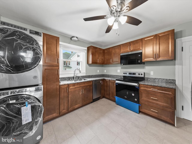 304 N Main St, Hebron, MD 21830 - kitchen with appliances with stainless steel finishes, stacked washer / drying machine, a sink, ceiling fan, and dark stone countertops