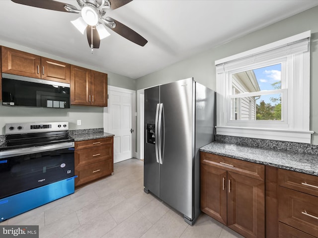 304 N Main St, Hebron, MD 21830 - kitchen featuring appliances with stainless steel finishes, a ceiling fan, dark stone countertops, and light tile patterned floors