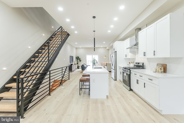 3231 Mercer St, Philadelphia, PA 19134 - kitchen with appliances with stainless steel finishes, wall chimney range hood, a sink, white cabinets, and recessed lighting