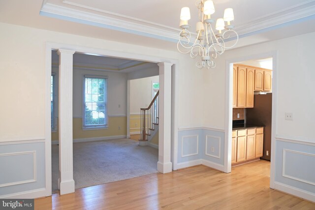11504 Woodview Ct, Hagerstown, MD 21742 - unfurnished dining area with a chandelier, light wood-style floors, ornamental molding, stairs, and ornate columns