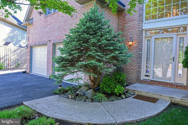 11504 Woodview Ct, Hagerstown, MD 21742 - property entrance with brick siding, asphalt driveway, and an attached garage