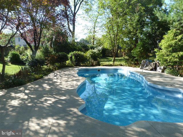 11504 Woodview Ct, Hagerstown, MD 21742 - outdoor pool with view of scattered trees and a patio
