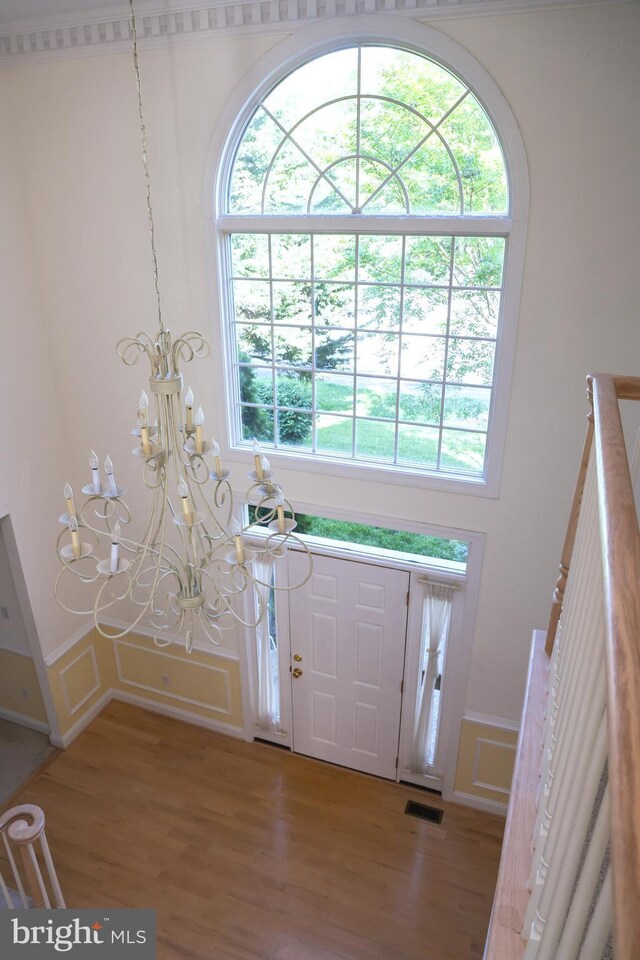 11504 Woodview Ct, Hagerstown, MD 21742 - entryway with a chandelier, healthy amount of natural light, light wood-type flooring, a wainscoted wall, and a decorative wall