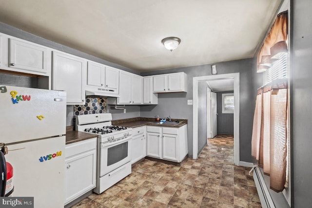 636 Elizabeth St, Beverly, NJ 08010 - kitchen featuring white appliances, under cabinet range hood, dark countertops, white cabinets, and a baseboard heating unit
