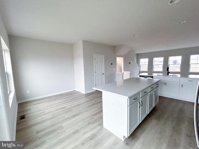 2385 Heyford Dr, Stephenson, VA 22656 - kitchen featuring a kitchen island, light wood-style flooring, a sink, and light countertops