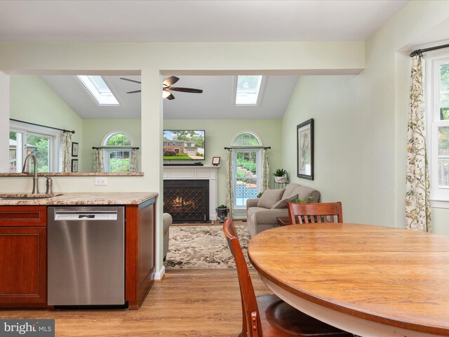 275 Tolstoy Ln, Severna Park, MD 21146 - kitchen featuring dishwasher, a skylight, vaulted ceiling, a sink, and light wood-style floors