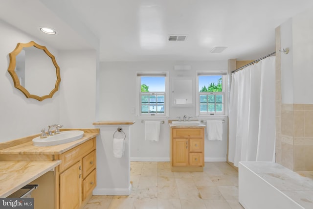 bathroom with two vanities, baseboards, a shower with shower curtain, and recessed lighting