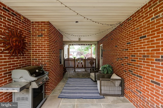 view of patio featuring a grill and a gate