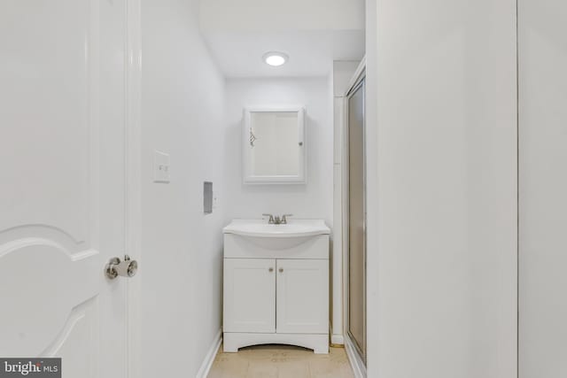 full bathroom with baseboards, vanity, tile patterned flooring, and an enclosed shower