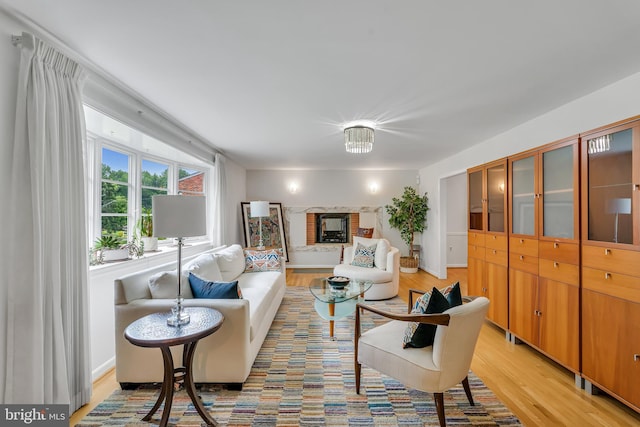 living room featuring light wood-style flooring and a brick fireplace