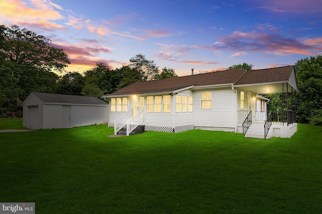 136 Pembrown Rd, Browns Mills, NJ 08015 - back of house at dusk with an outdoor structure, a yard, entry steps, and roof with shingles