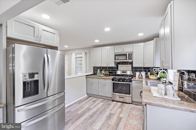 136 Pembrown Rd, Browns Mills, NJ 08015 - kitchen with appliances with stainless steel finishes, a sink, decorative backsplash, light wood finished floors, and recessed lighting