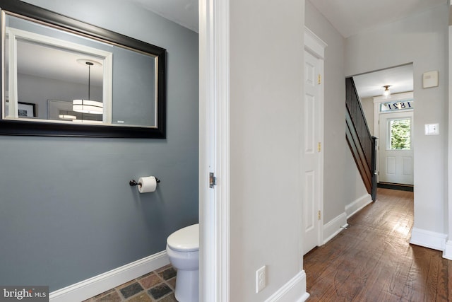 bathroom with baseboards, toilet, and wood finished floors