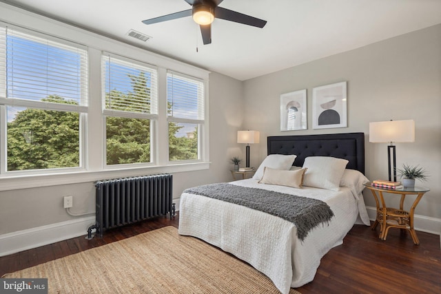bedroom featuring radiator, baseboards, wood finished floors, and a ceiling fan