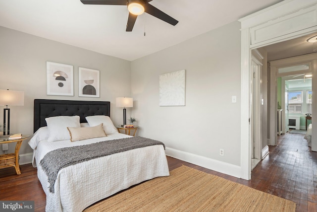 bedroom featuring baseboards, wood finished floors, and a ceiling fan