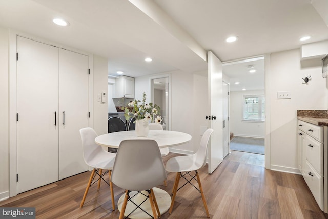 dining room with wood finished floors, baseboards, washing machine and dryer, and recessed lighting