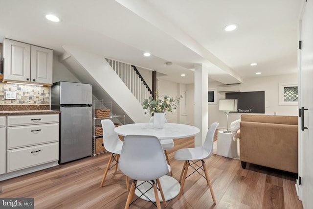dining room with stairway, light wood-style floors, recessed lighting, and a wall mounted AC
