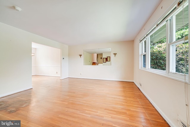 12102 Hunters Ln, Rockville, MD 20852 - unfurnished living room with light wood-style floors and baseboards