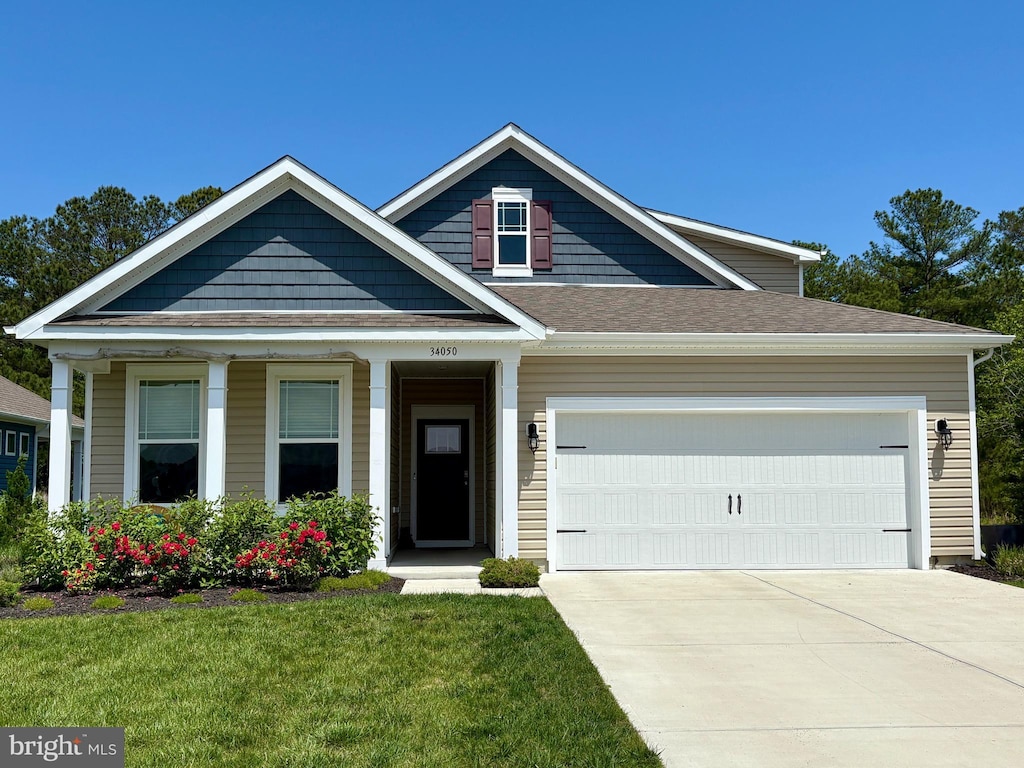 view of front of house featuring concrete driveway, a garage, and a front lawn