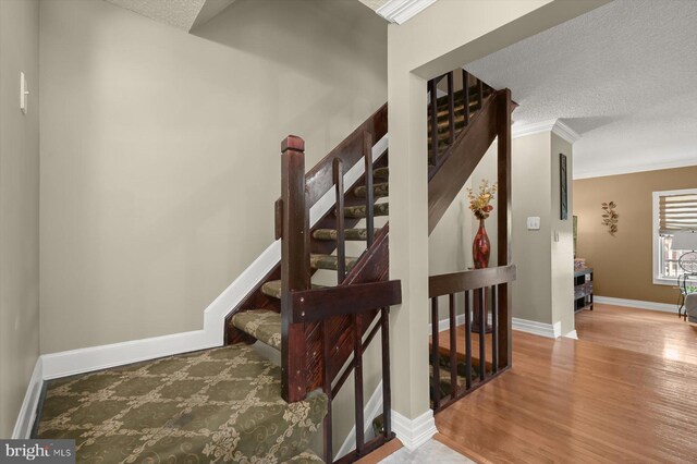 737 Saint Michaels Dr, Bowie, MD 20721 - stairway featuring wood finished floors, baseboards, ornamental molding, and a textured ceiling